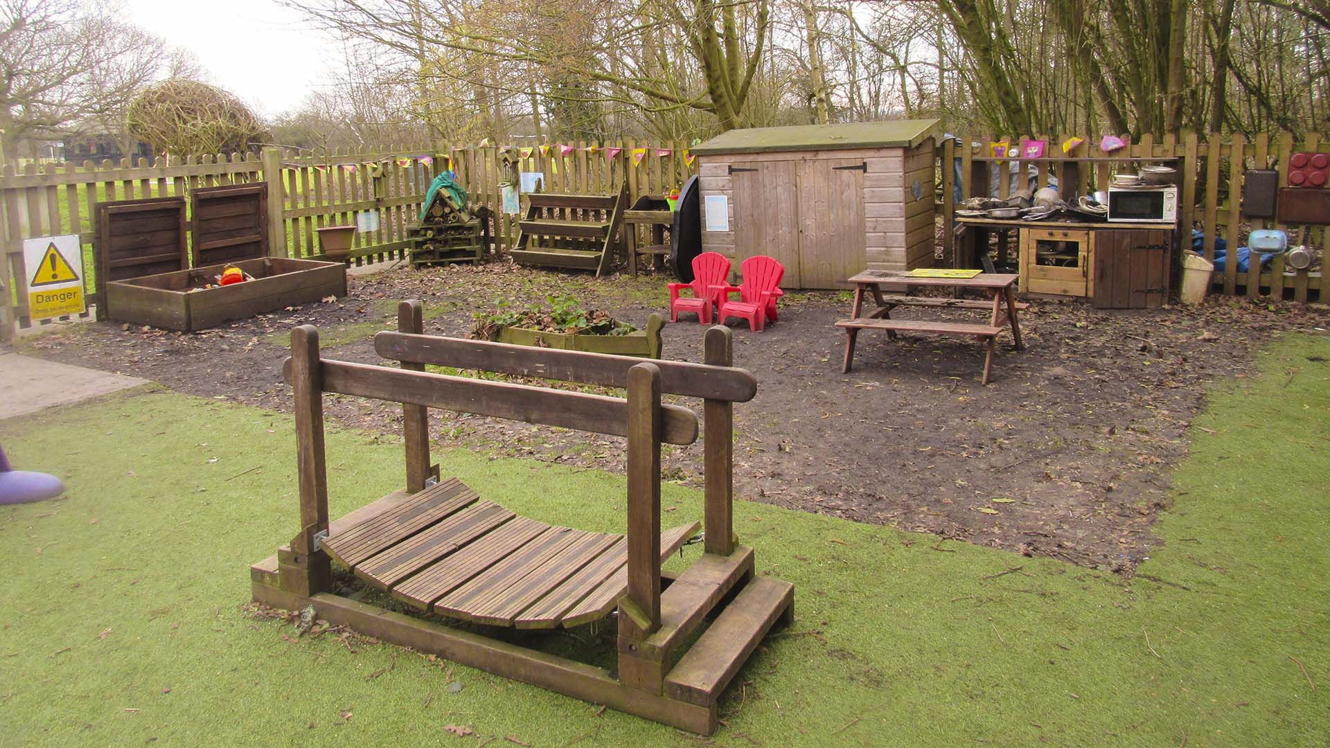 The pre-school 'natural area' featuring digging box, bug hotel, potting shed, and mud kitchen.